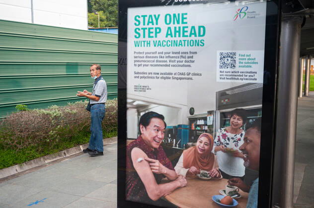 11 11 2020, Singapore, Republic of Singapore, Asia An advertising poster at a bus stop in the midst of the coronavirus crisis Covid 19 promotes a general vaccination campaign and health care Meanwhile, the number of new infections daily has dropped to a manageable minimum and there are almost only imported cases, which are immediately quarantine