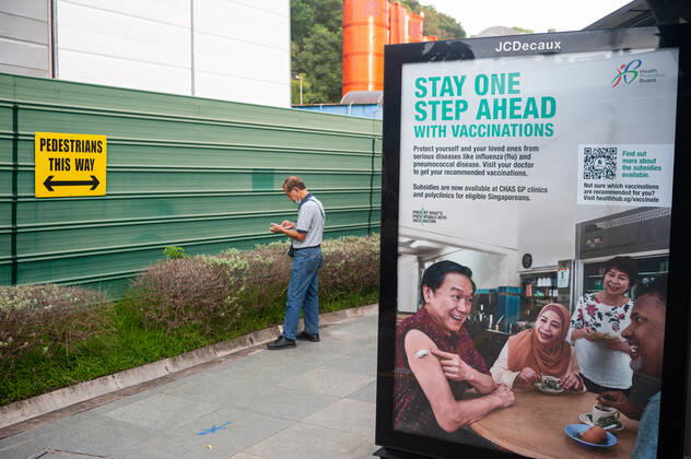 11 11 2020, Singapore, Republic of Singapore, Asia An advertising poster at a bus stop in the midst of the coronavirus crisis Covid 19 promotes a general vaccination campaign and health care Meanwhile, the number of new infections daily has dropped to a manageable minimum and there are almost only imported cases, which are immediately quarantine