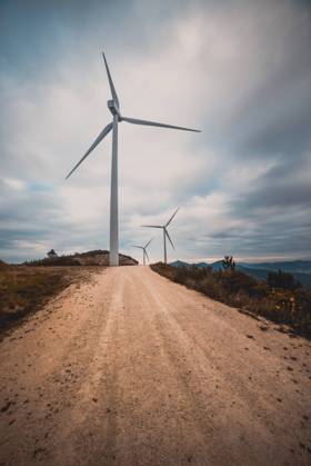 IMAGO Creative: Klimawandel - Zukunft und Innovation Row of modern windmills standing on side of narrow countryside road on cloudy day Copyright: xAlbertoxMenendezx Model Released