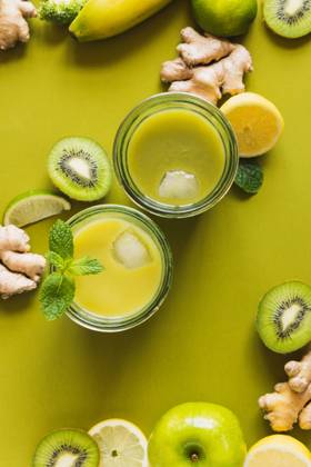 From above of glasses with healthy detox drinks with ice cubes placed on wooden tray with apple and ginger Copyright: xAllaxMachuttx Model Released