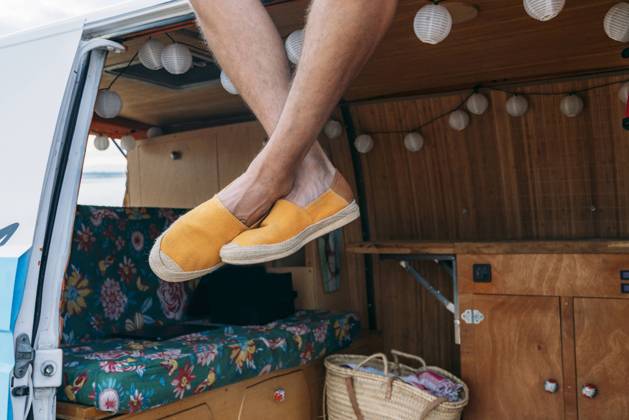 IMAGO Creative: Klimawandel - Nachhaltiges Reisen Legs of crop person in yellow fabric shoes hanging from car roof in bright day Copyright: xJuanxMiguelxApariciox Model Released
