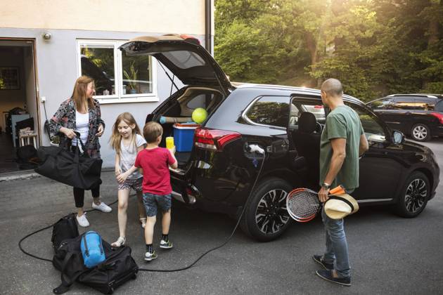 IMAGO Creative, Jahreszeit Sommer, Sommerferien Family with luggage and black electric car in back yard , model released, property released Copyright: xMaskotx , MA53227