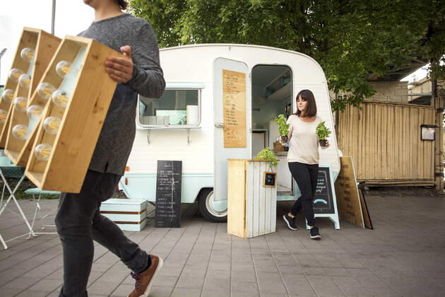 Owners carrying letter M and potted plants while walking outside food truck on street , model released, property released Copyright: xMaskotx , MA54313