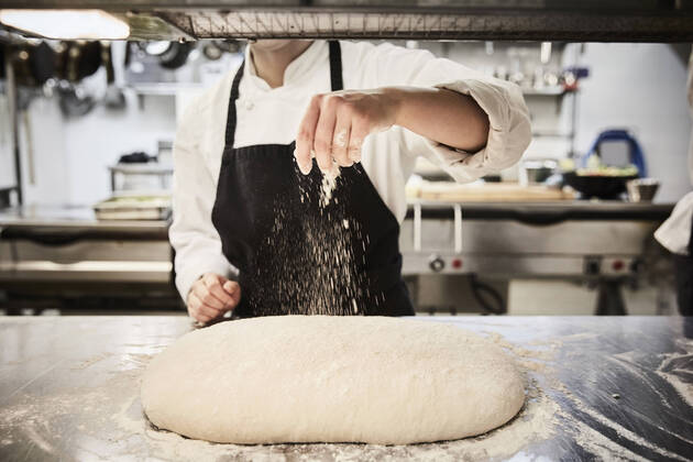 Midsection of female chef student sprinkling flour on dough at commercial kitchen , model released, property released Copyright: xMaskotx , MA55077