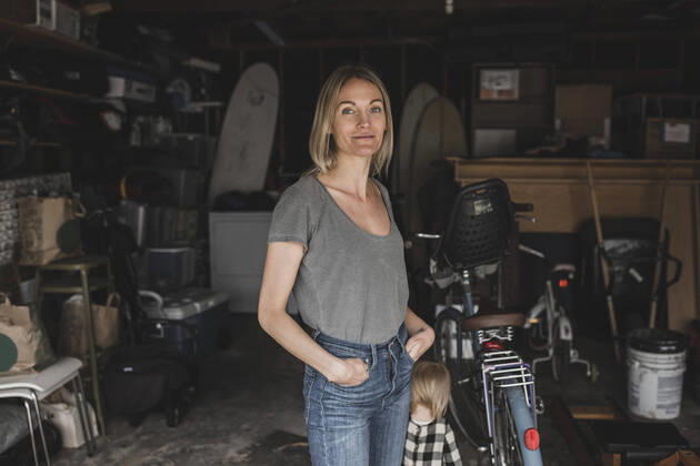 Portrait of mid adult woman standing with hands in pockets by daughter at storage room , model released, property released Copyright: xMaskotx , MA56083