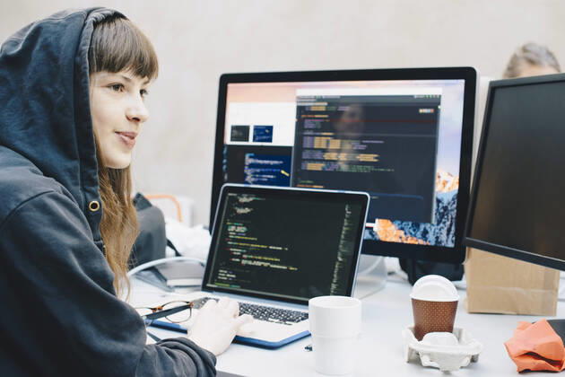 Side view of female computer programmer looking away while using laptop at desk in office , model released, property released Copyright: xMaskotx , MA56956