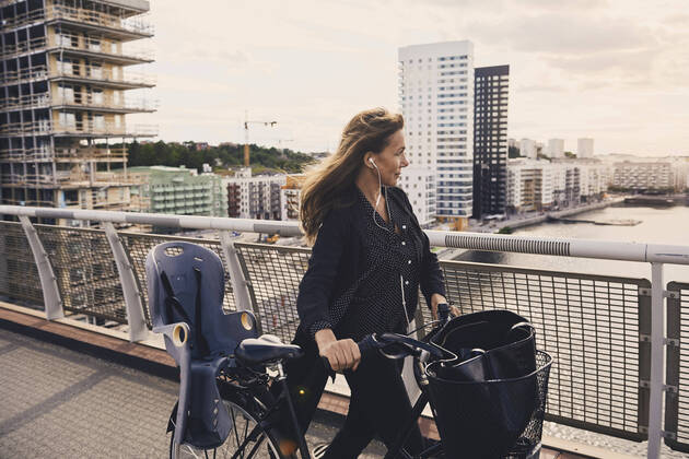 IMAGO Creative: Business, Innovative Technologie-Lösungen Mature woman walking with bicycle on footbridge in city , model released Copyright: xMaskotx , MA58753