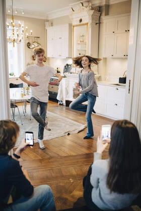 Friends photographing teenage boy and girl dancing at home , model released, property released Copyright: xMaskotx , MA61709