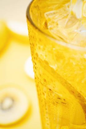 From above crop detail of glass of fresh beverage with lemons and kiwi placed in yellow background in studio Copyright: xGustavoxPozox Model Released