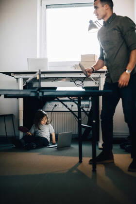 Full length of businessman playing table tennis while boy using laptop at creative office , model released, property released Copyright: xMaskotx , MA63794