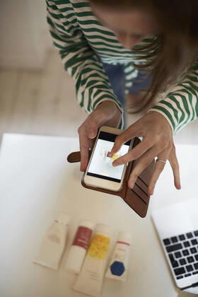 High angle view of blogger photographing beauty products with smart phone at home , model released, property released Copyright: xMaskotx , MA64743