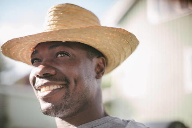 Smiling mid adult man looking away while wearing straw hat during garden party , model released, property released Copyright: xMaskotx , MA67059