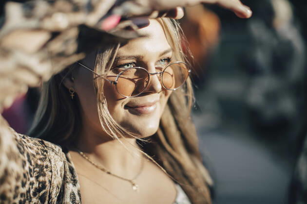 Close-up of smiling woman sheilding eyes while looking away in summer , model released Copyright: xMaskotx , MA69814