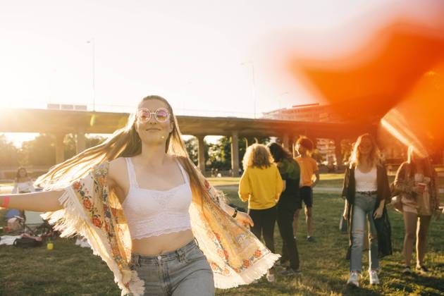 Smiling woman dancing with friends in background at event on sunny day , model released Copyright: xMaskotx , MA69923