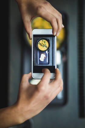 Directly above view of female blogger photographing pumpkin soup and crispbread through smart phone at creative office , model released, property released Copyright: xMaskotx , MA70050