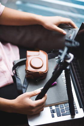 High angle view of young female influencer vlogging through mobile phone on tripod at creative office , model released, property released Copyright: xMaskotx , MA70064