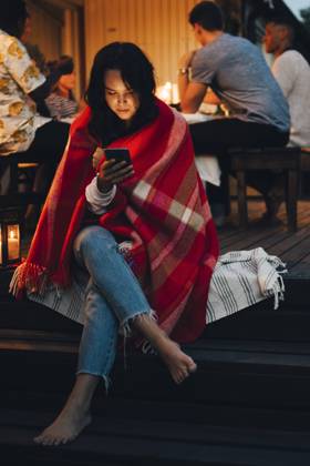 Young woman using smart phone while friends in background during dinner party , model released, property released Copyright: xMaskotx , MA70308
