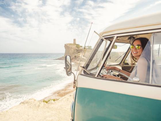Side view of car with woman drawing on sandy empty beach with foamy waves in bright sunny day Copyright: xJavierxDexLaxTorrex Model Released
