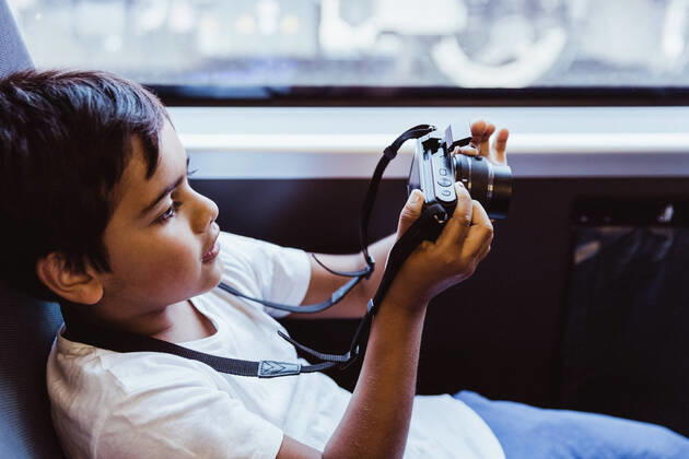 Boy photographing through camera while sitting in train , model released, property released Copyright: xMaskotx , MA74769