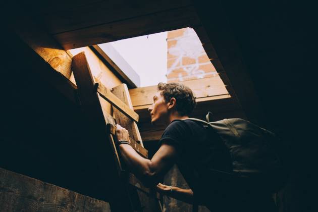IMAGO Kreativ: Urbane Kultur - Sommer auf den Dächern Side view of young man carrying backpack while climbing on ladder towards terrace , model released, property released Copyright: xMaskotx , MA75669