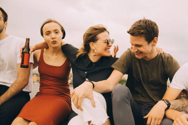 Cheerful friends talking while sitting together against sky , model released Copyright: xMaskotx , MA75699