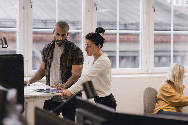 IMAGO Creative: Business, Innovative Technologie-Lösungen Businesswoman discussing with male coworker over digital tablet at office , model released, property released Copyright: xMaskotx , MA78801
