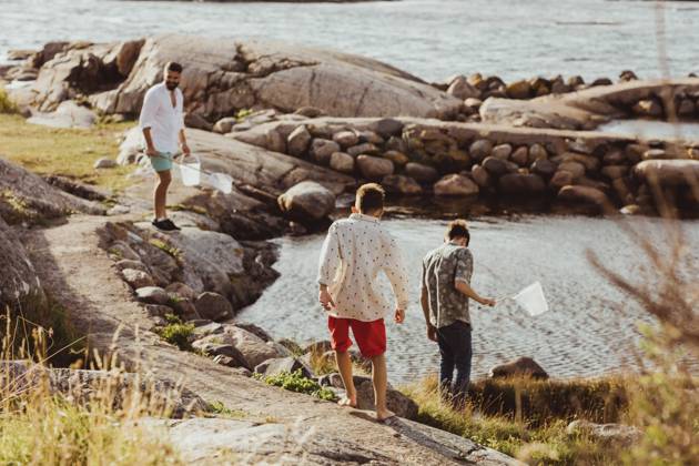 IMAGO Creative, Jahreszeit Sommer, Sommerferien Rear view of boy with sibling while father standing over rock during weekend Sweden, Gothenburg, model released Copyright: xMaskotx , MA78854