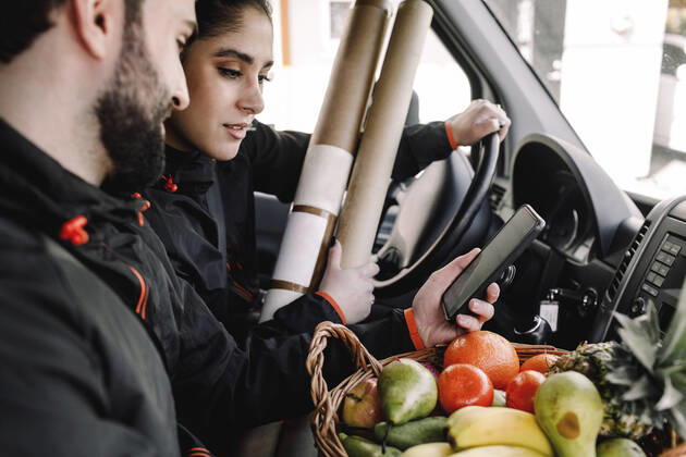 Delivery man and woman with fruits and packages in truck Sweden, Stockholm, model released Copyright: xMaskotx , MA80276
