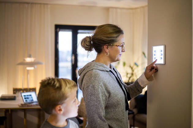 IMAGO Creative: Corporate: Klimaschutz, Digitalisierung und Urbanisierung Son looking at mother using digital tablet mounted on wall at smart home Sweden, Stockholm, model released, property released Copyright: xMaskotx , MA80404