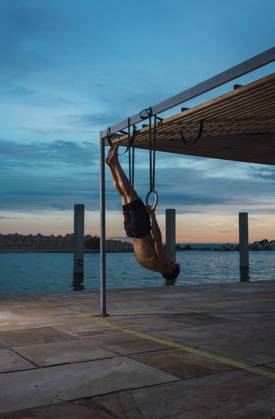 IMAGO Creative, Jahreszeit Sommer, Sommer in der Stadt Athletic man balancing on gymnastic rings, Model released Copyright: xLuisxMarioxHernandezx MR