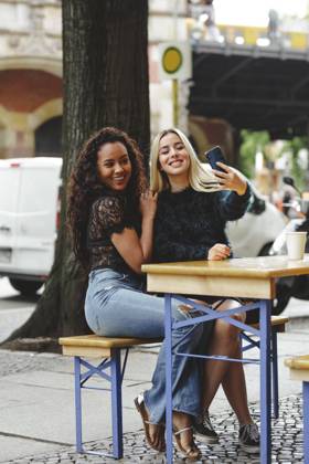 IMAGO Creative, Fr?hling, Start der Stra?encafe-Saison beautiful young women sitting in Berlin street cafe taking selfie, Model released Copyright: xMiguelxVallsx MR