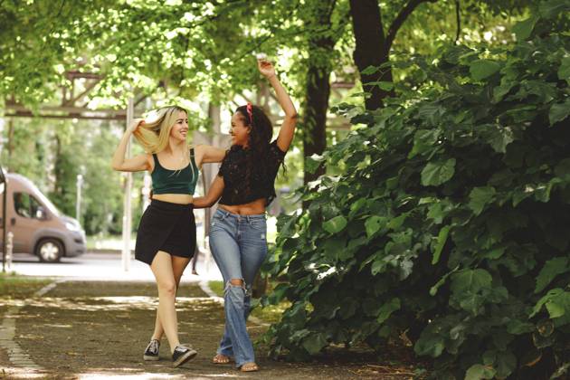 IMAGO Creative: Sommer, Sommertage im Stadtpark Cheerful women walking on green summer street in Berlin on sunny day, Model released Copyright: xMiguelxVallsx MR