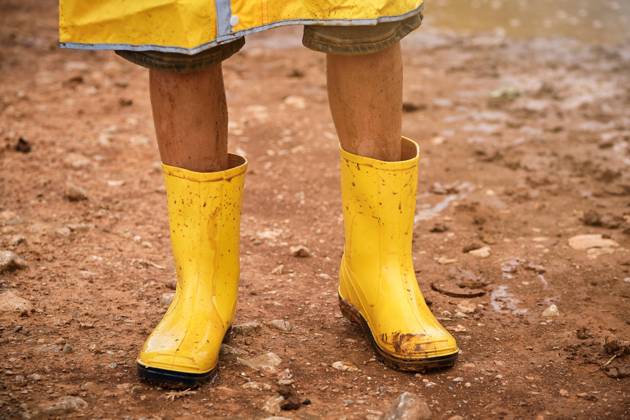 Detail of some legs with yellow dirty muddy water boots in the middle of a path in the forest, Model released Copyright: xPhilippexDegrootex MR