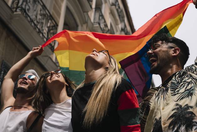 Group of friends with a flag of gay pride in the city of Madrid Copyright: xJosexLuisxCarrascosax Model Released