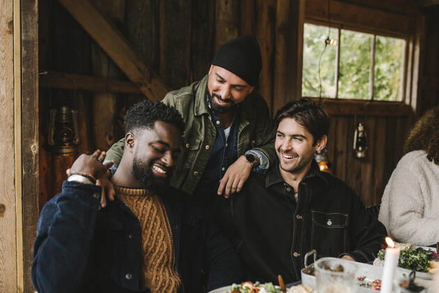 Smiling man talking to male friends at dinner party Sweden, Stockholm, model released, property released Copyright: xMaskotx , MA83209