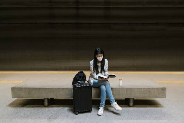 Female passenger reading book while sitting at metro station model released Symbolfoto EGAF01000