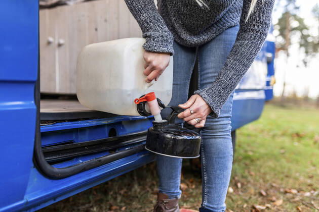IMAGO Creative: Klimawandel - Nachhaltiges Reisen Mid adult woman pouring water in camping teapot model released Symbolfoto  WPEF03783