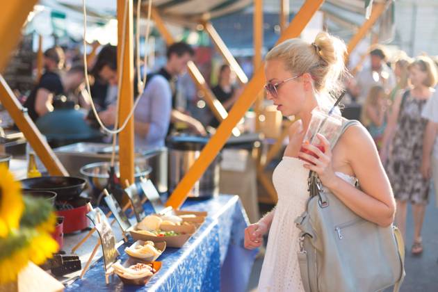 Woman buying meal at street food festival. Beautiful blonde caucasian lady wearing white summer dress buying freshly prepared meal at a local street food festival. Urban international kitchen event in Ljubljana, Slovenia, in summertime., model releasedwoman, food, market, grill, barbecue, street, people, young, shop, beautiful, healthy, outdoors, festival, fresh, lady, customer, urban, female, city, face, drink, stall, european, buy, vegetable, person, lifestyle, produce, attractive, summer, beverage, purchase, organic, portrait, marketplace, tourism, tourist, event, market stall, market stand, leisure, buying, stand, juise, sunglasses, cook, hat, casual, crowd, look,