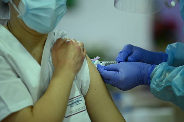 A health worker gets the vaccine after Araceli, 96, who is the first person in Spain to be vaccinated against COVID-19, on the first day of vaccination, at the Los Olmos nursing home in Guadalajara, Castilla La-Mancha (Spain), on 27 December 2020. The first doses of the vaccine developed by Pfizer and BioNtech laboratories arrived in Spain yesterday, December 26, at a Pfizer warehouse in Guadalajara by land from Puurs (Belgium). From Monday, weekly deliveries will be made to the autonomous communities with an average of 350,000 doses prioritized for four population groups: residents and health and social-health personnel in homes for the elderly and disabled; front-line health personnel; other health and social-health personnel and large no Copyright: xMoncloax 3494829