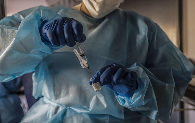 A nursing home health worker injects the vaccine doses during the first day of vaccination against Covid-19 in Spain, at the Virgen del Milagro nursing home in Rafelbunyol, Valencia, Spain, on 27 December 2020. The first doses of the vaccine developed by Pfizer and BioNtech laboratories arrived in Spain yesterday, December 26, at a Pfizer warehouse in Guadalajara by land from Puurs (Belgium). From Monday, weekly deliveries will be made to the autonomous communities with an average of 350,000 doses prioritized for four population groups: residents and health and social-health personnel in homes for the elderly and disabled; front-line health personnel; other health and social-health personnel and large non-institutionalized dependents. 27 DE Copyright: xRoberxSolsonax 3494930