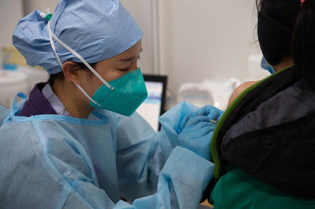 (210102) -- BEIJING, Jan. 2, 2021 -- A medical worker injects a COVID-19 vaccine at a temporary vaccination site in Beijing, capital of China, Jan. 2, 2021. Beijing started administering COVID-19 vaccines among specific groups of people with higher infection risks. Nine groups of people aged 18 to 59 will receive the vaccine before the Spring Festival of 2021, which falls on Feb. 12. These include frontline customs inspectors of imported cold-chain goods and personnel working in the overseas and domestic transportation sector. ) CHINA-BEIJING-COVID-19-VACCINATION (CN) ChenxZhonghao 