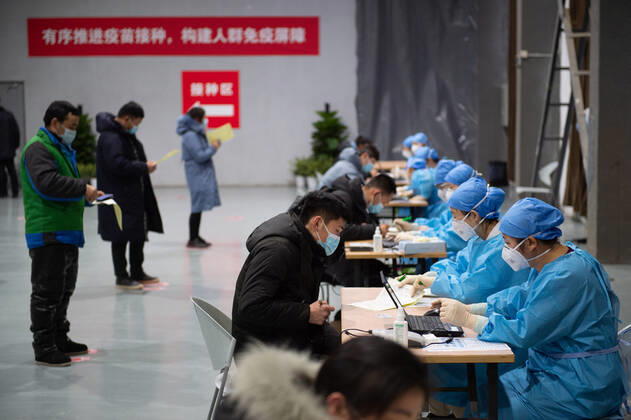(210102) -- BEIJING, Jan. 2, 2021 -- People fill the informed consent form out before the COVID-19 vaccination at a temporary vaccination site in Beijing, capital of China, Jan. 2, 2021. Beijing started administering COVID-19 vaccines among specific groups of people with higher infection risks. Nine groups of people aged 18 to 59 will receive the vaccine before the Spring Festival of 2021, which falls on Feb. 12. These include frontline customs inspectors of imported cold-chain goods and personnel working in the overseas and domestic transportation sector. ) CHINA-BEIJING-COVID-19-VACCINATION (CN) ChenxZhonghao 