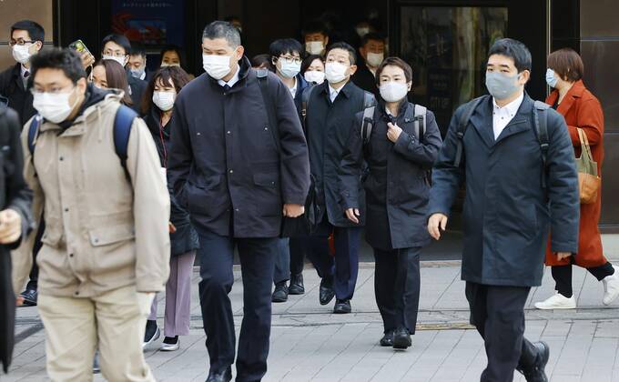 Year s first work in Japan Commuters wearing face masks walk near JR Shimbashi Station in Tokyo on the first work day of the year on Jan. 4, 2021, amid the coronavirus pandemic. 