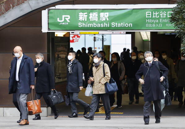 Year s first work in Japan Commuters wearing face masks walk near JR Shimbashi Station in Tokyo on the first work day of the year on Jan. 4, 2021, amid the coronavirus pandemic. 