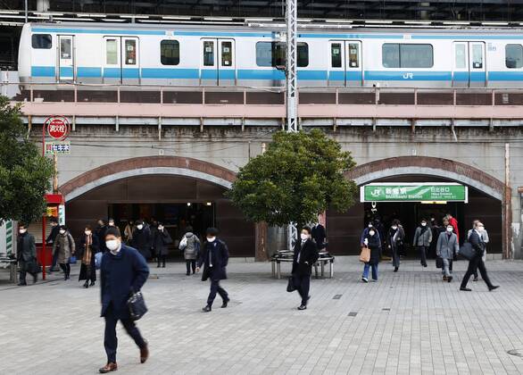 Year s first work in Japan Commuters wearing face masks walk near JR Shimbashi Station in Tokyo on the first work day of the year on Jan. 4, 2021, amid the coronavirus pandemic. 