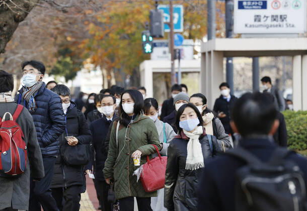 Year s first work in Japan Commuters wearing face masks walk in Tokyo s Kasumigaseki area on the first work day of the year on Jan. 4, 2021, amid the coronavirus pandemic. 