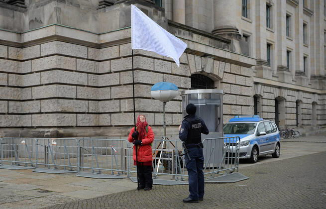 Berlin in the phase of the coronavirus crisis, in the picture woman with flag in front of the Reichstag, it voted against the third law for the protection of the population in an epidemic situation of national scope and the names of 235 members of the Bundestag who voted against the law, right a policeman, 08 01 2021, Copyright: xSebastianxRäppoldx xMatthiasxKochx