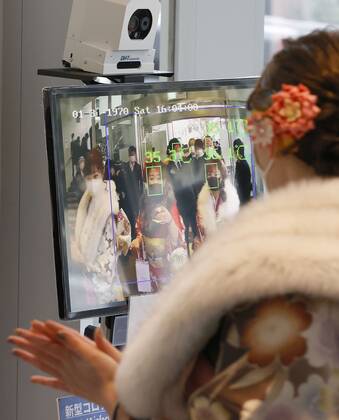 Coming-of-age ceremony under virus state of emergency A woman has her temperature checked before entering the venue of a coming-of-age ceremony in Tokyo s Suginami Ward on Jan. 11, 2021, as the capital is under a coronavirus state of emergency.