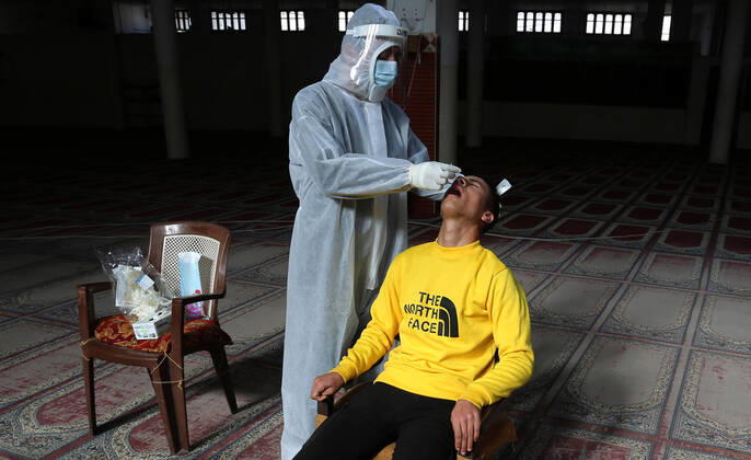 January 11, 2021, Deir Al-Balah, Gaza Strip, Palestinian Territory: A Palestinian medical worker wearing protective gear, takes a random swab sample for COVID-19 testing inside a mosque, in Deir al-Balah, central of Gaza Strip, on January 11, 2021. The Palestinian Authority (PA) has said it expects to receive its first COVID-19 vaccine doses in March under a deal with British drug giant AstraZeneca, and accused Israel of ignoring its responsibilities to ensure vaccines are available in occupied territory Deir Al-Balah Palestinian Territory - ZUMAap3_ 20210111_zaf_ap3_031 Copyright: xAshrafxAmrax