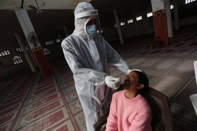 January 11, 2021, Deir Al-Balah, Gaza Strip, Palestinian Territory: A Palestinian medical worker wearing protective gear, takes a random swab sample for COVID-19 testing inside a mosque, in Deir al-Balah, central of Gaza Strip, on January 11, 2021. The Palestinian Authority (PA) has said it expects to receive its first COVID-19 vaccine doses in March under a deal with British drug giant AstraZeneca, and accused Israel of ignoring its responsibilities to ensure vaccines are available in occupied territory Deir Al-Balah Palestinian Territory - ZUMAap3_ 20210111_zaf_ap3_036 Copyright: xAshrafxAmrax